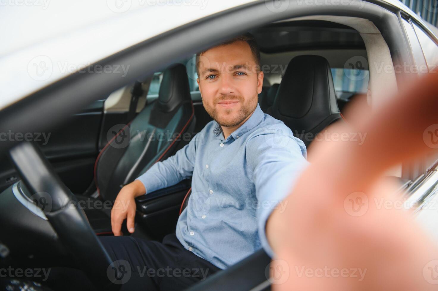 zakenman Holding stuurinrichting wiel terwijl het rijden modern elektrisch auto Aan de straat weg. zelfverzekerd Mens het rijden duur auto. bestuurder draaien stuurinrichting wiel in luxueus auto Aan reis foto