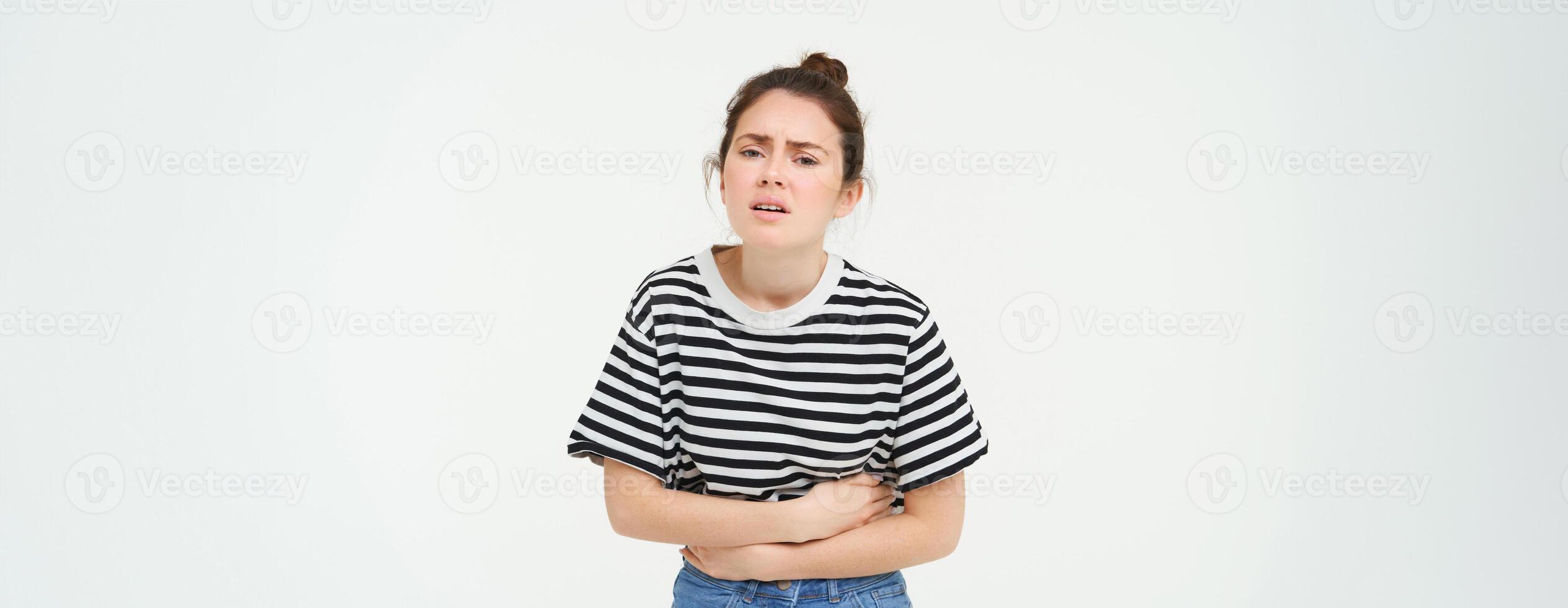 beeld van jong vrouw Holding handen Aan haar buik, gevoel ongemak, menstruatie- periode krampen, behoeften pijnstillers, staat over- wit achtergrond foto