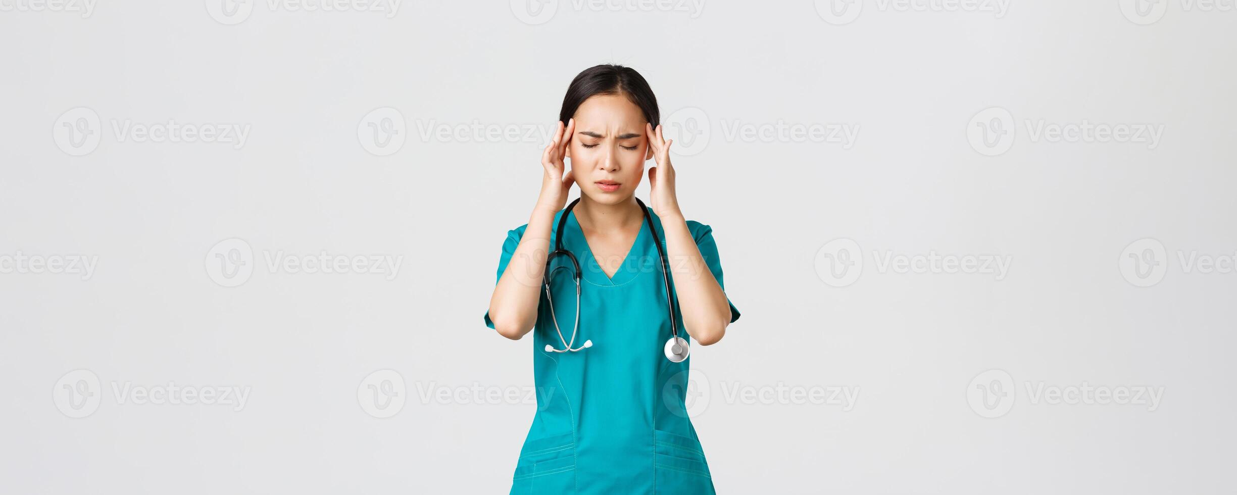 covid19, gezondheidszorg arbeiders, pandemisch concept. overwerkt en moe jong Aziatisch vrouw verpleegster dichtbij ogen, grimassen van hoofdpijn, voelen duizelig, nacht verschuiving met coronavirus patiënten, wit achtergrond foto