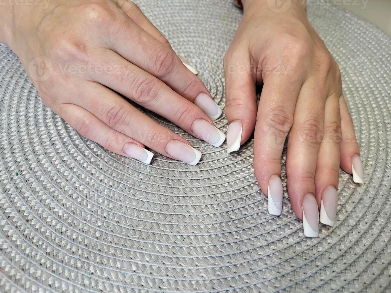 mooi vrouw handen met delicaat manicure Aan de achtergrond van een grijs servet. vrouwen nagels. foto