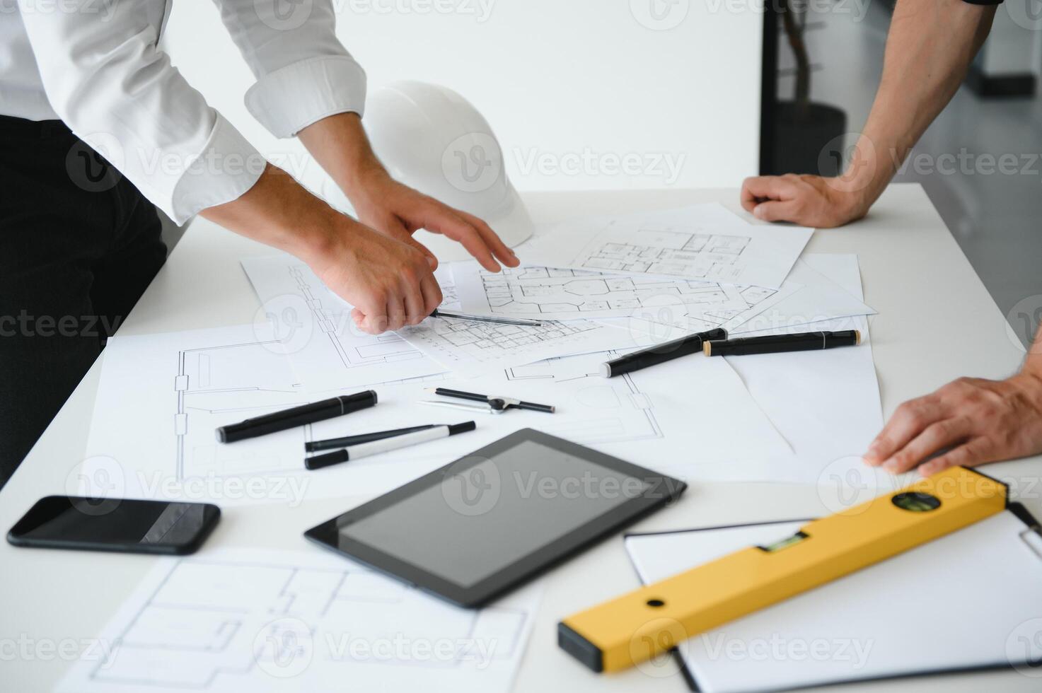 ingenieur of architect samenspel werken Aan bouw project met gebouw model- en blauwdruk in kantoor. bouw concept. foto