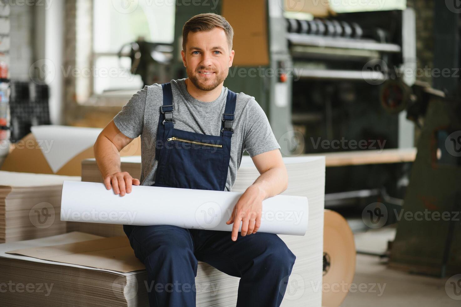 glimlachen en gelukkig medewerker. industrieel arbeider binnenshuis in fabriek. jong technicus met wit moeilijk hoed. foto