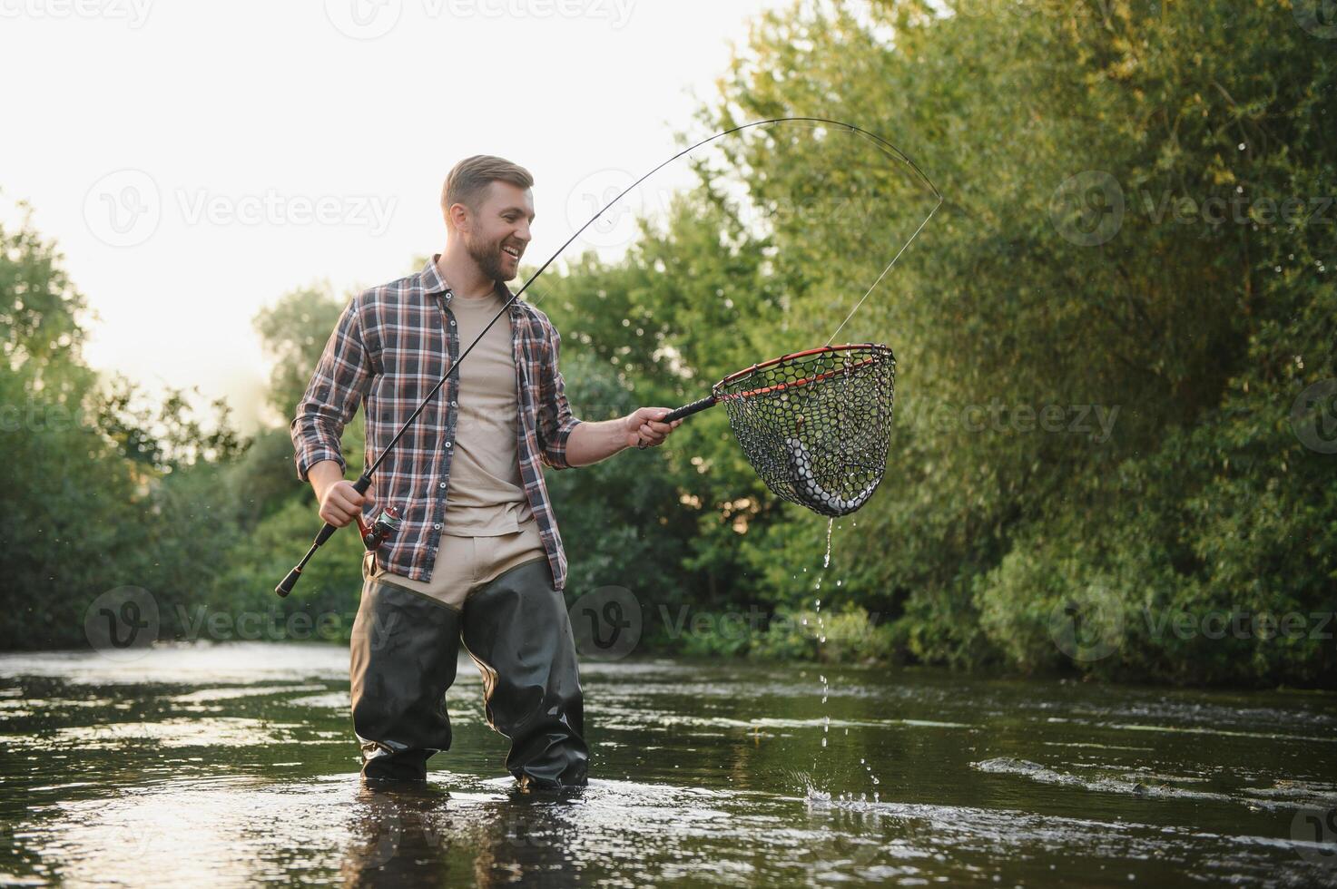 visser vangsten een forel Aan de rivier- in zomer foto