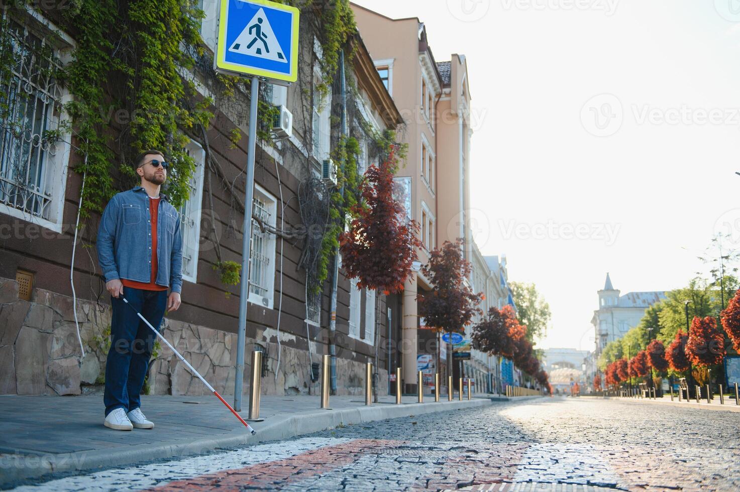 Blind Mens wandelen Aan trottoir Holding stok foto