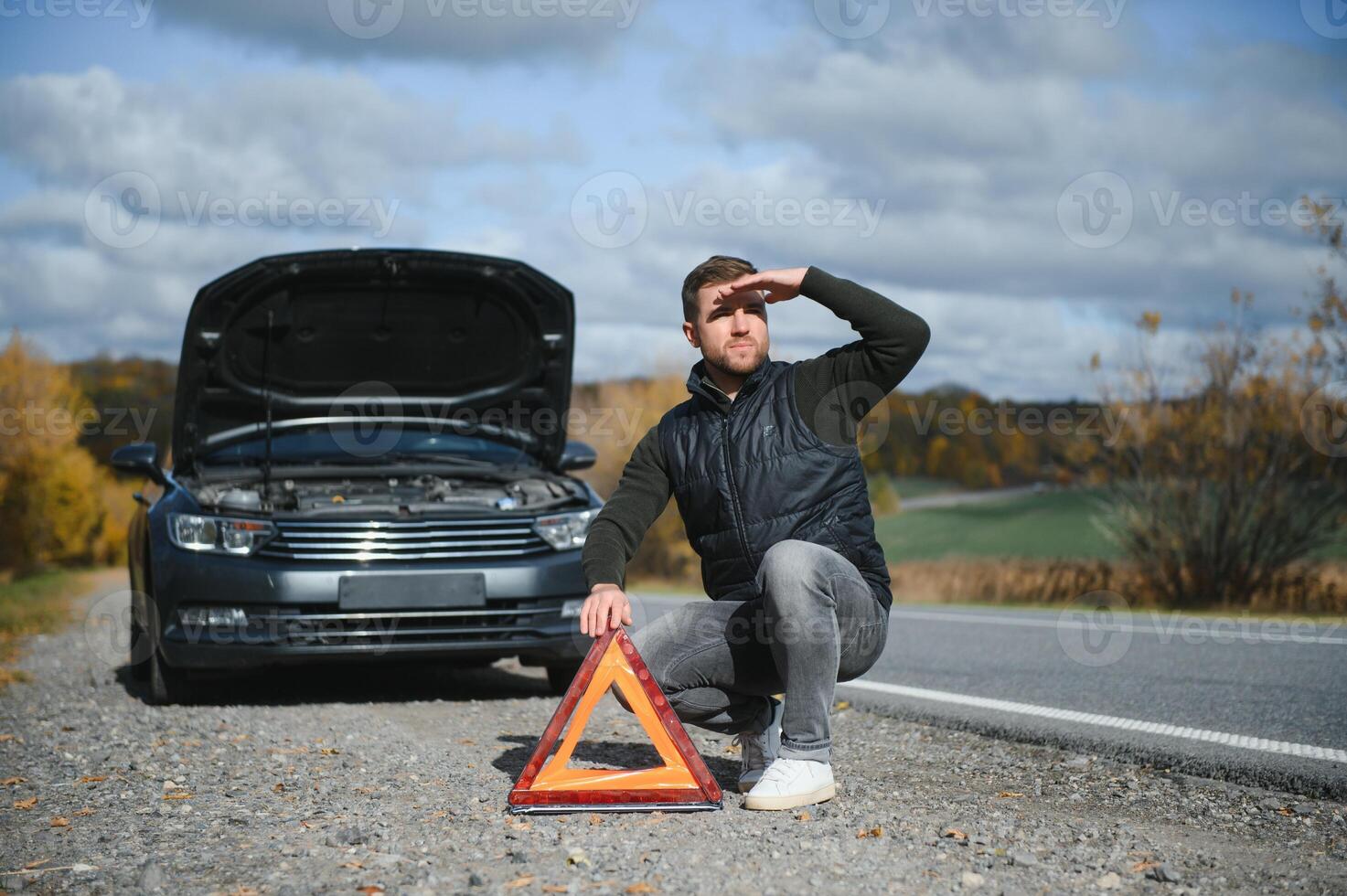 Mens met gebroken auto in de midden- van de weg. foto