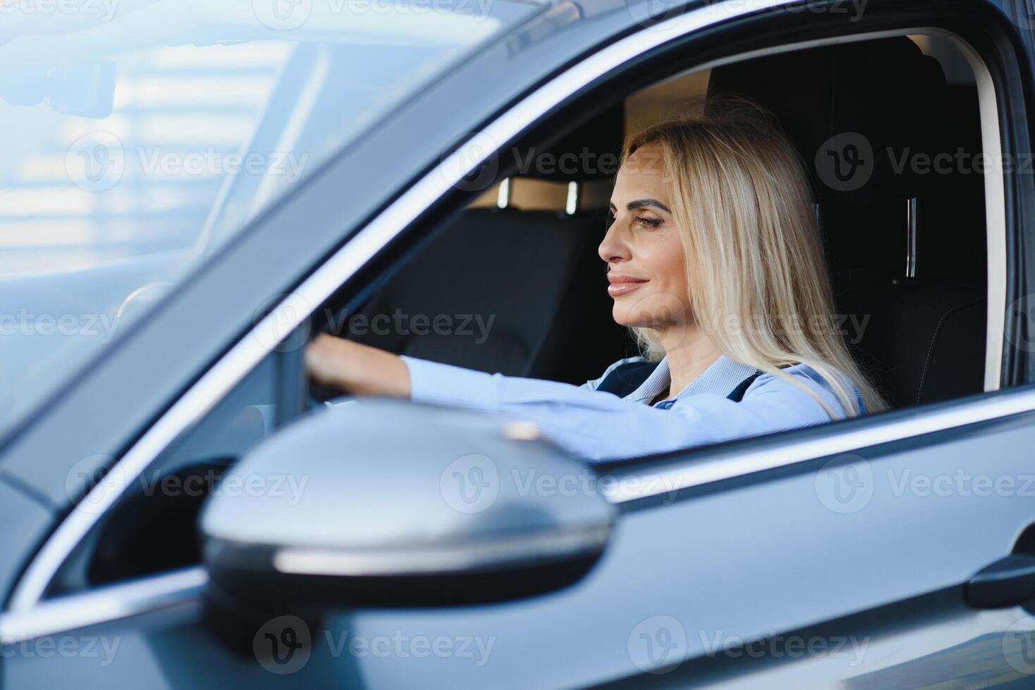 portret van bedrijf elegant middelbare leeftijd vrouw in auto. foto