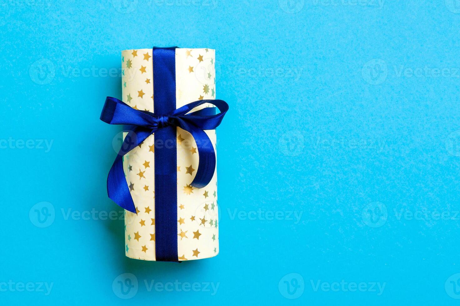 geschenk doos met blauw boog voor Kerstmis of nieuw jaar dag Aan blauw achtergrond, top visie met kopiëren ruimte foto