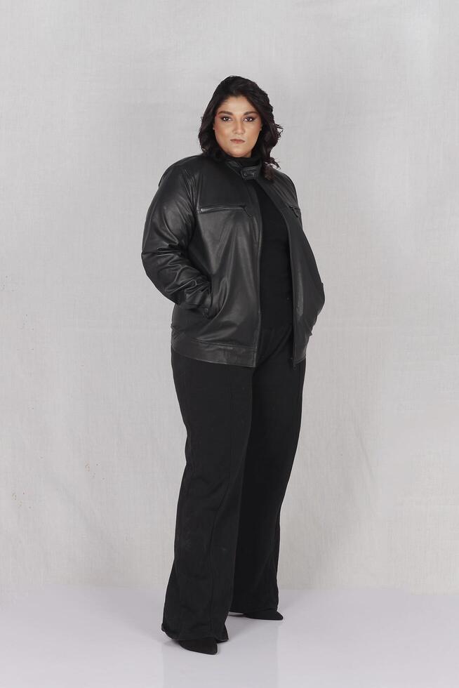 een vrouw in een zwart leer jasje en zwart broek foto