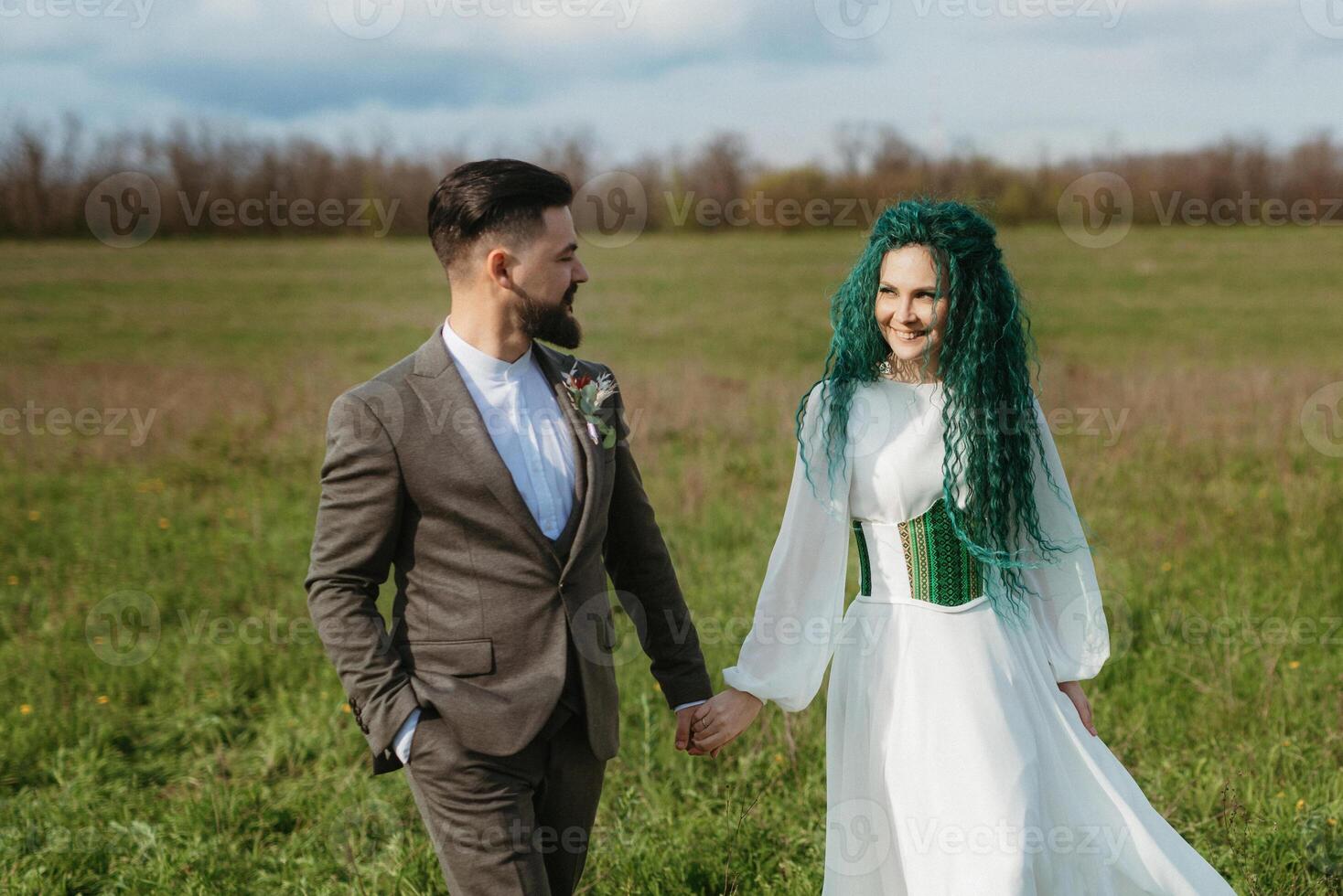 een gebaard bruidegom en een meisje met groen haar- dans en ronddraaien foto