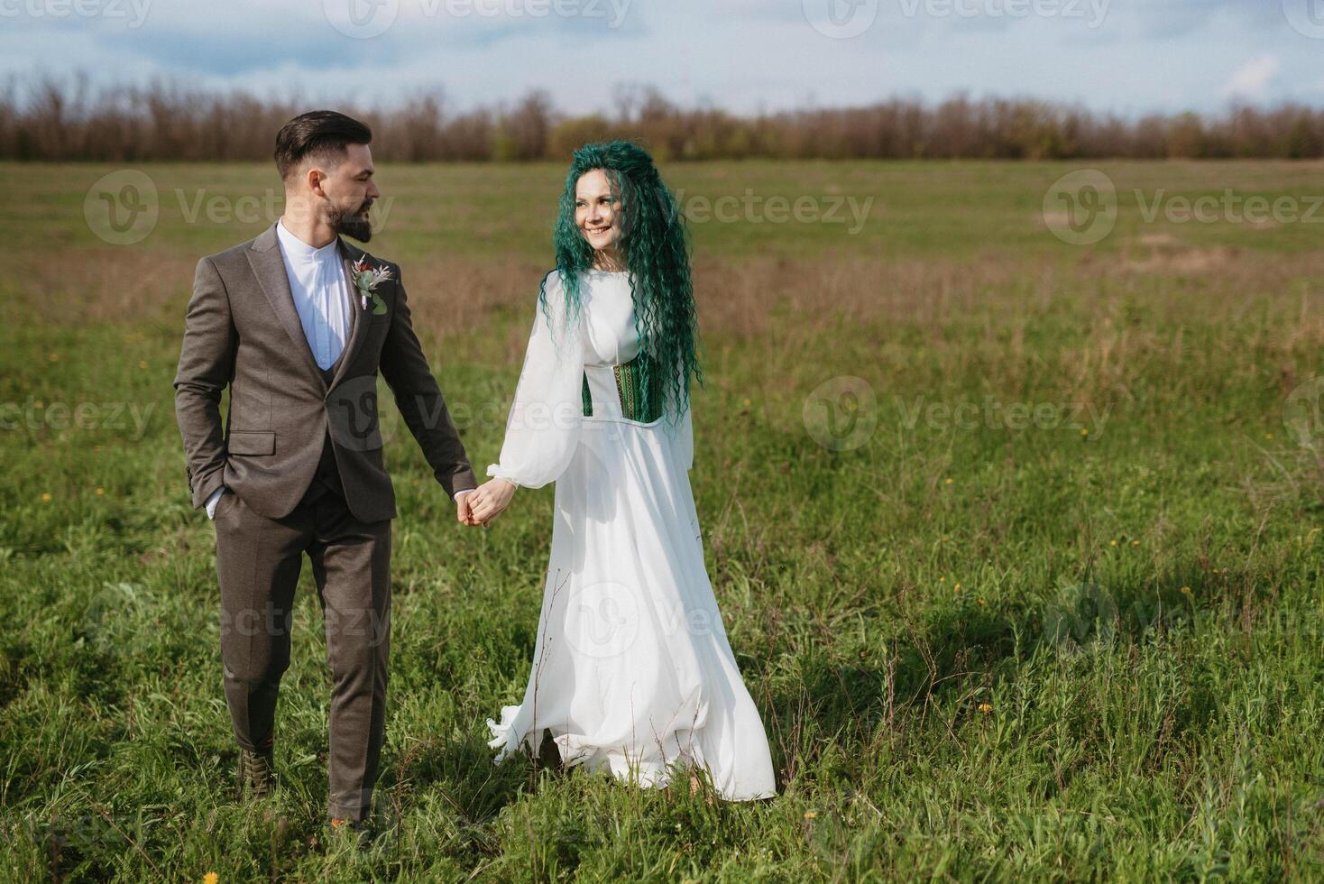 een gebaard bruidegom en een meisje met groen haar- dans en ronddraaien foto
