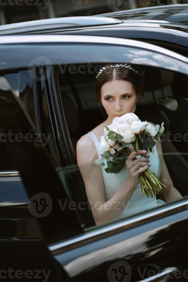 bruid met een zwart auto in de buurt een glas wolkenkrabber foto