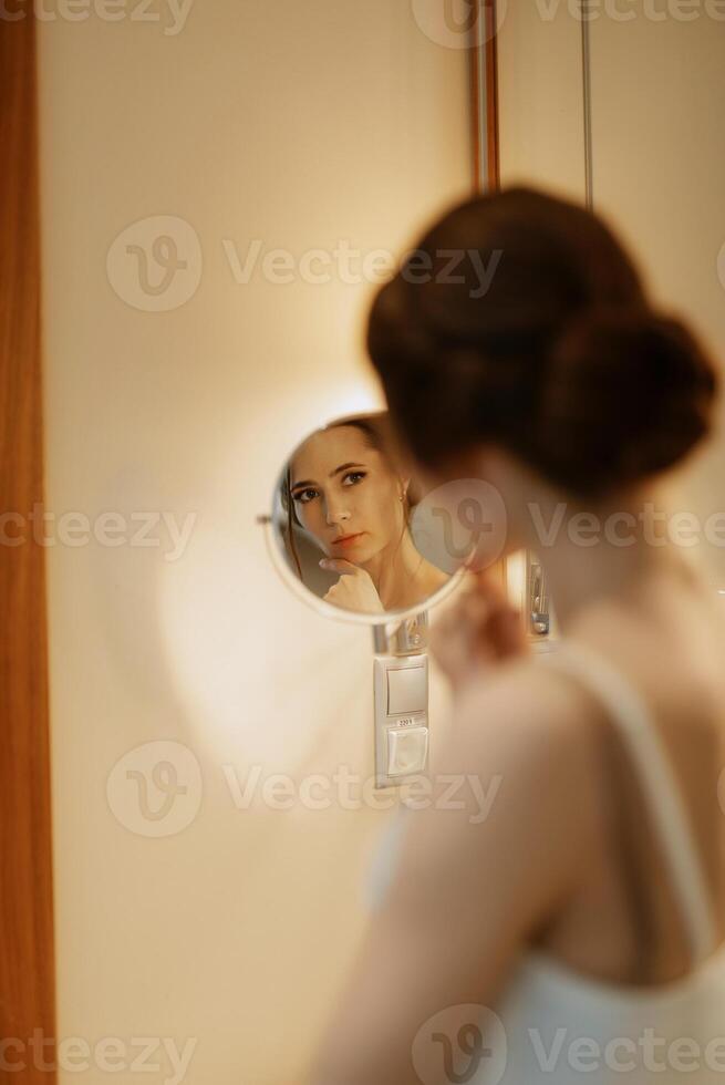 bruid in een sluier met bedenken verven haar lippen foto
