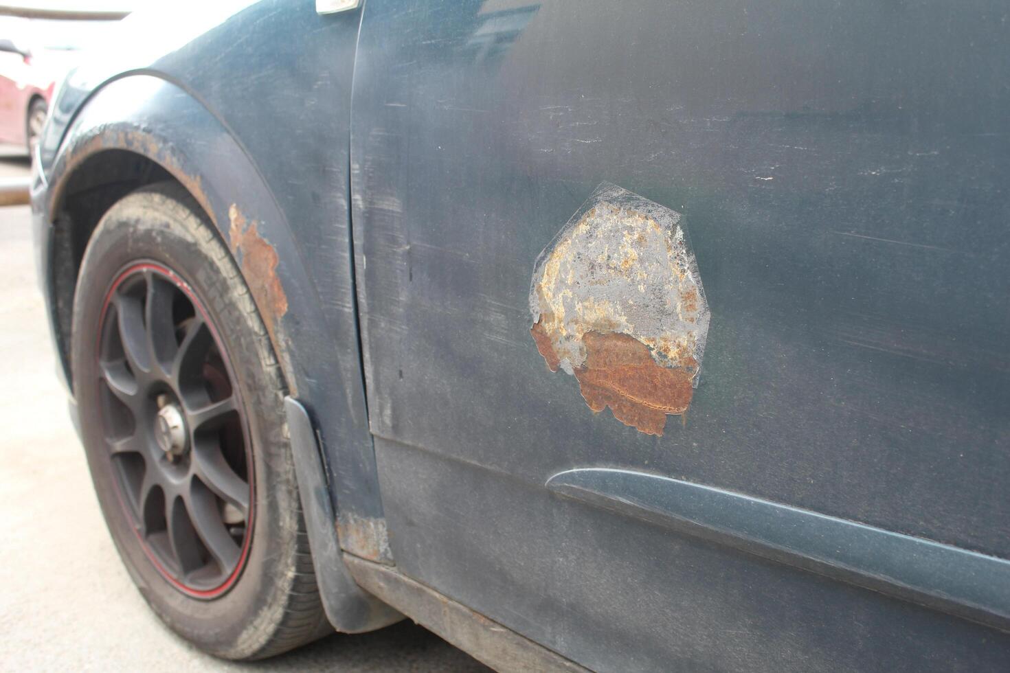 Sankt petersburg Rusland - 08 19 2023 vel metaal corrosie van oud wit auto. roestig rommelig oppervlak. beschadigd grunge vuil textuur. Roest achtergrond. beschermen auto- concept. verf werk. foto