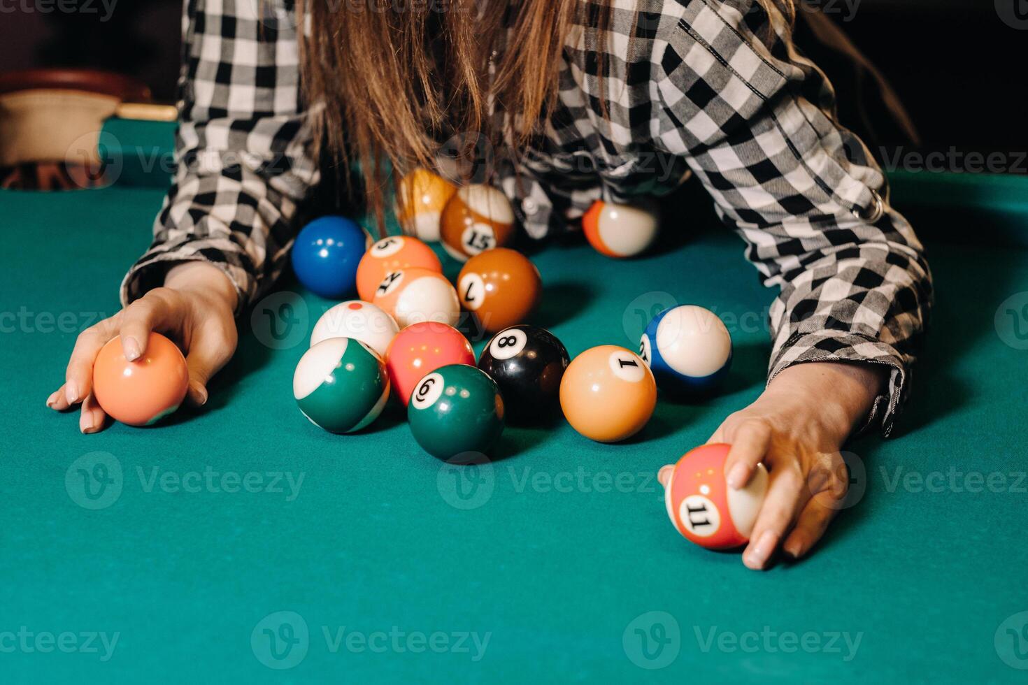 een meisje in een hoed in een biljart club met ballen in haar handen.spelen zwembad foto