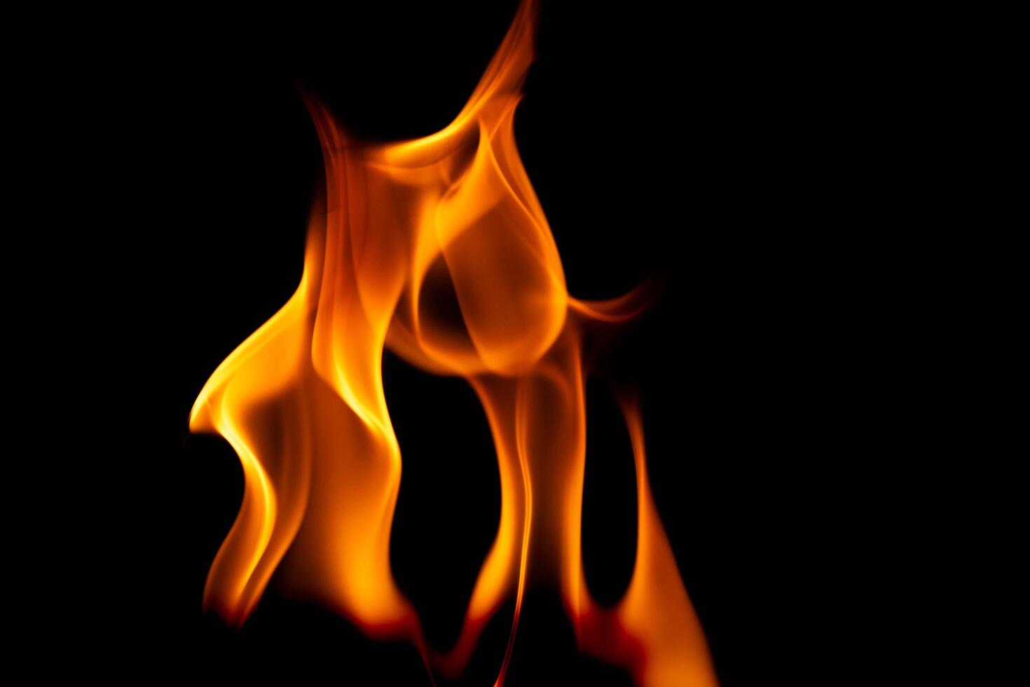 heet vlammen Aan een zwart achtergrond. mooi vlam van brand in de donker. abstract van brandend vlammen en rook. foto