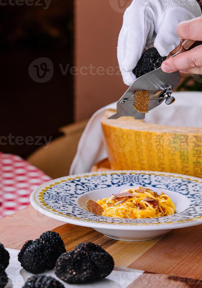 chef rooster truffel krullen Aan pasta met Parmezaanse kaas foto