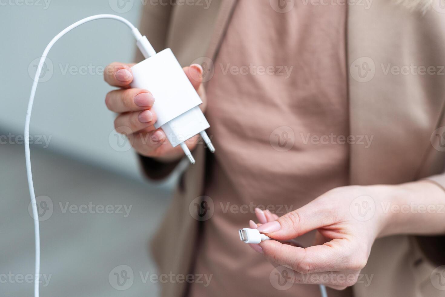 dichtbij omhoog van hand- Holding USB opladen kabel voor telefoon met wit achtergrond. foto