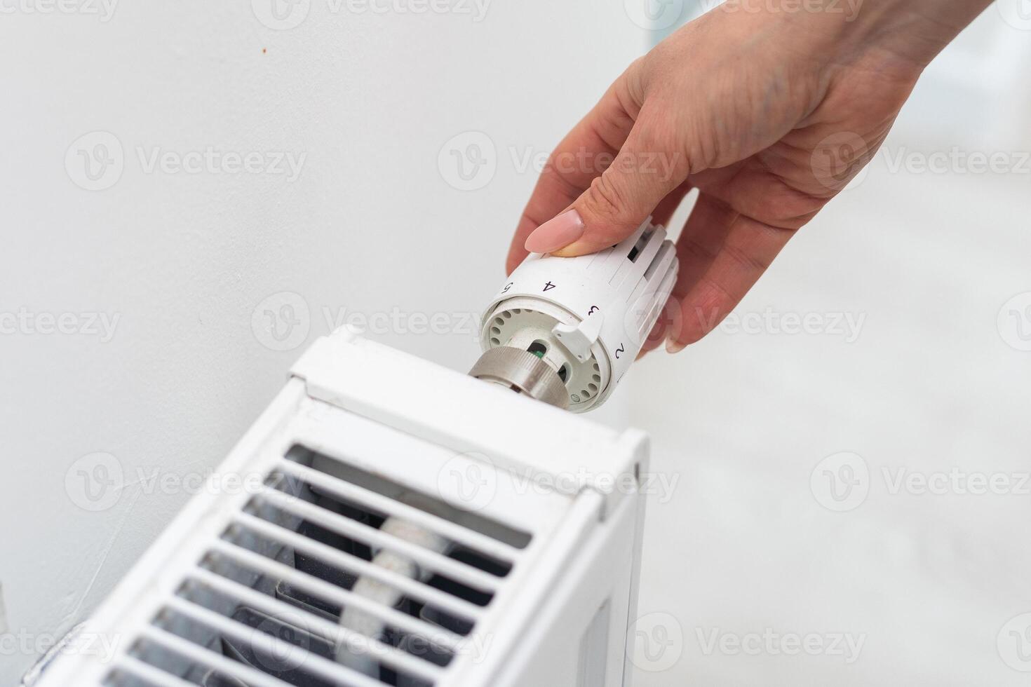 warmte radiator knop. vrouw hand- aanpassen temperatuur Aan verwarming radiator foto