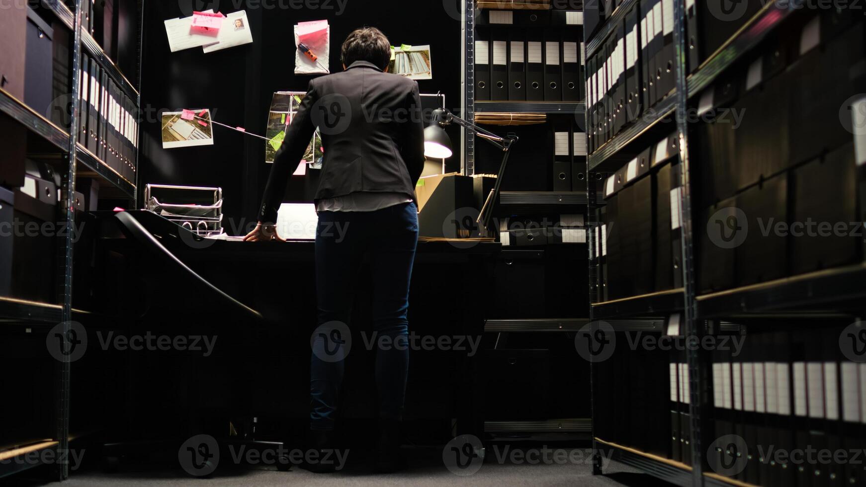 Politie officier bijeenkomst intelligentie- over de geval, op zoek Bij bord aanwijzingen naar ontdekken verborgen waarheid. vrouw aan het doen detective werk met invasie van privacy, proberen naar vangst dader. handheld schot. foto