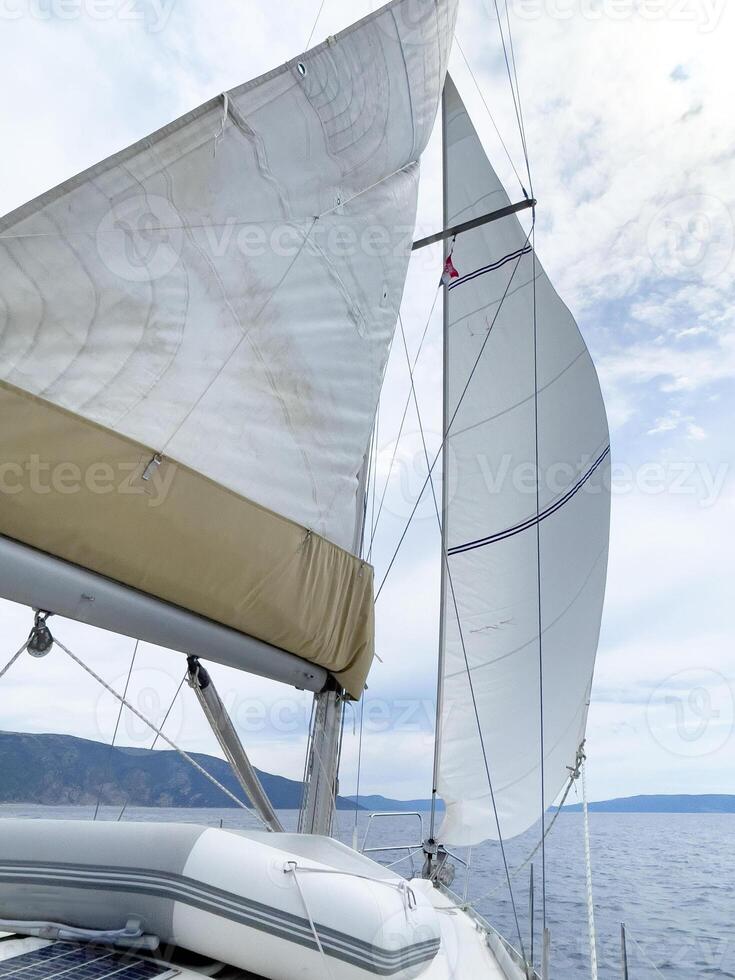 een zeilboot met een wit zeil en een wit zeil foto