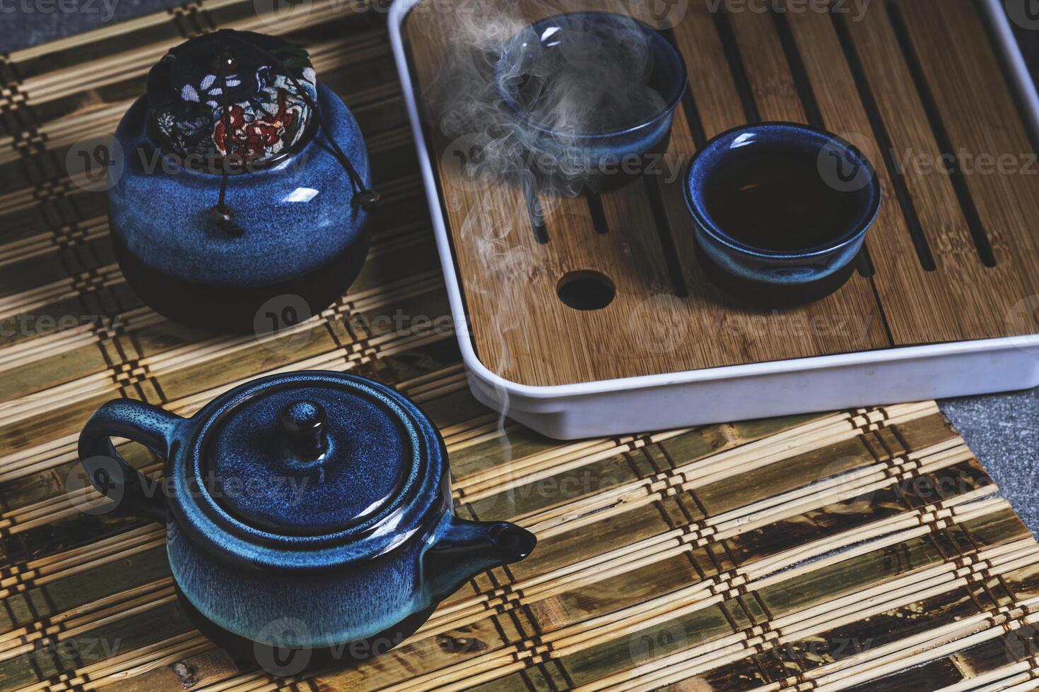 serviesgoed voor thee ceremonie . blauw thee reeks pottenbakkerij Aan bamboe servet. foto