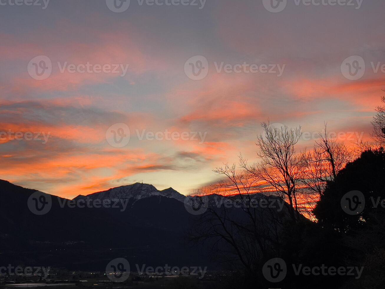 een zonsondergang over- de bergen met een rood lucht foto