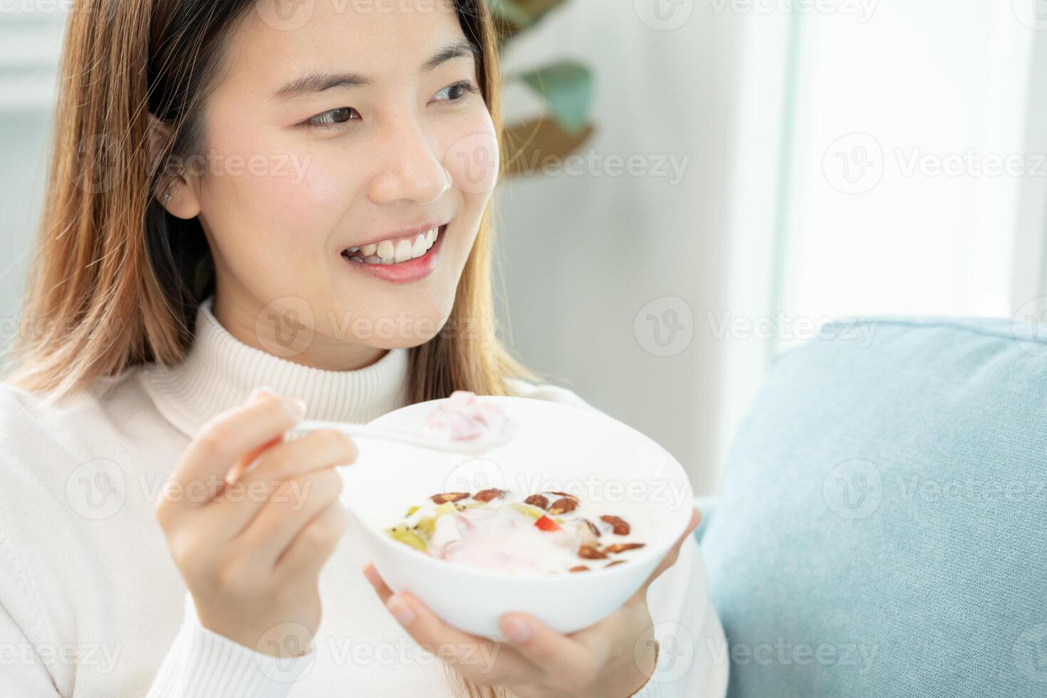 gezond voedsel. mooi vrouw meisje genieten eten yoghurt, muesli, vers fruit Aan ontbijt Gezondheid in huis. gelukkig jong vrouw glimlach Aan ochtend- mooi zo emotie. diëten, ontgiften, eetpatroon, schoon eten, vegetarisch foto