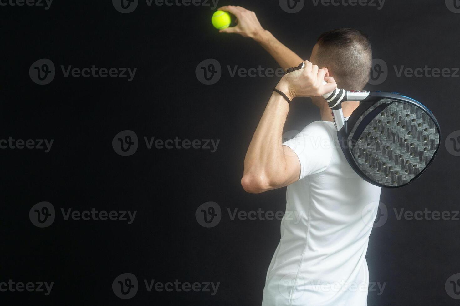 peddelen tennis speler klaar voor dienen Aan grijs achtergrond foto