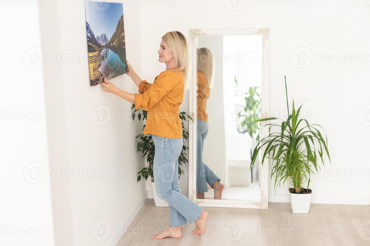 canvas afdrukken met galerij inpakken interieur decor. vrouw blijft hangen landschap fotografie Aan wit muur. handen Holding foto canvas afdrukken