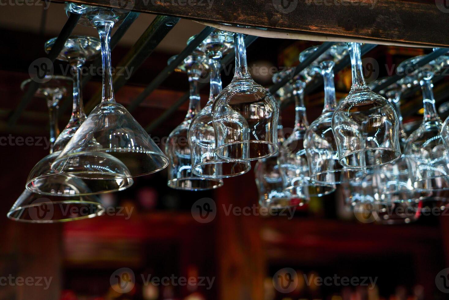 transparant wijn bril voor drankjes hangen over- de bar teller Aan de achtergrond van de interieur van de cafe. detailopname foto