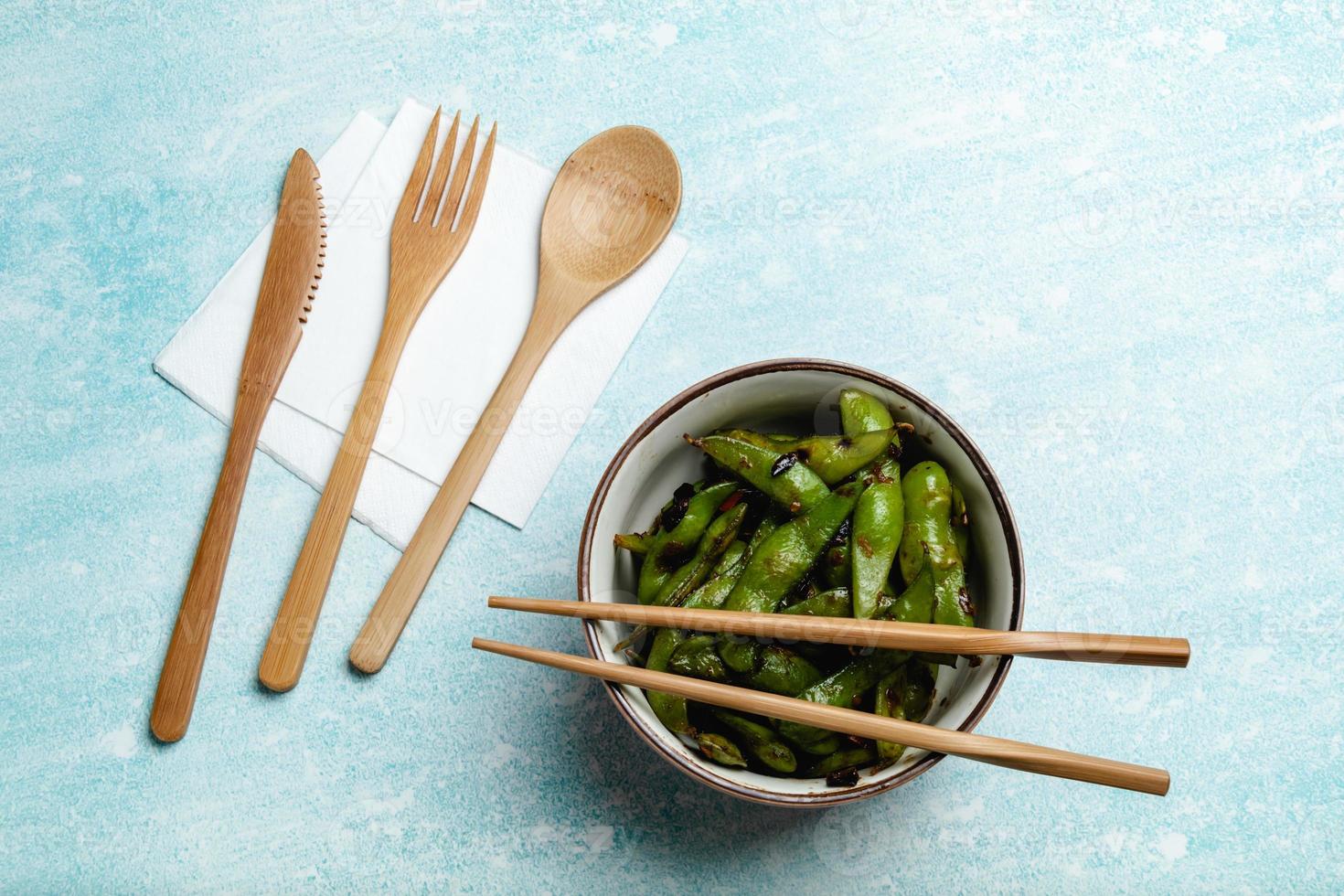 gekookte edamame op een blauw tafelblad. snack soja peulen foto