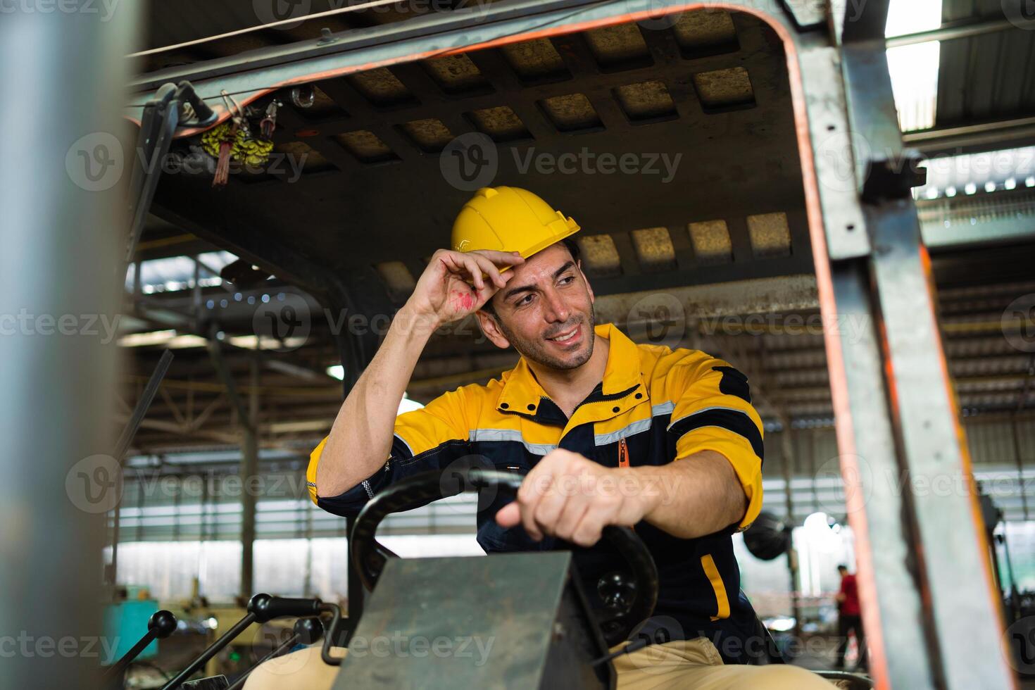 mannetje arbeider schijven een heftruck in een industrieel houder magazijn. mannetje fabriek arbeider het rijden een heftruck in de fabriek mannetje ingenieur het rijden een auto in een fabriek. foto