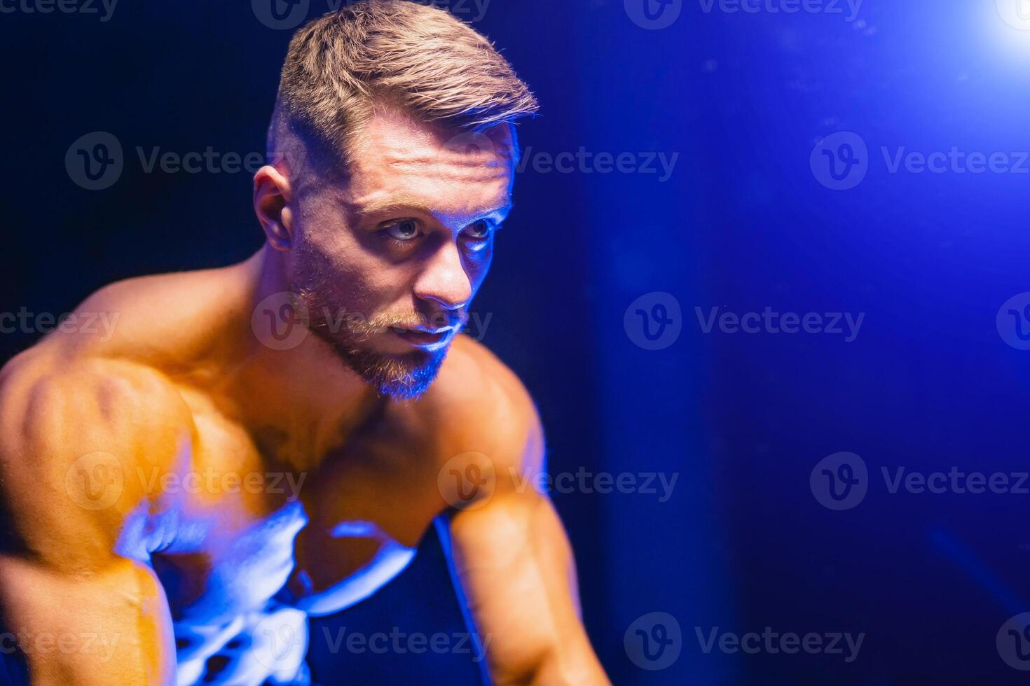 portret van een sexy jong atletisch sport blond haar Mens met een naakt torso. foto