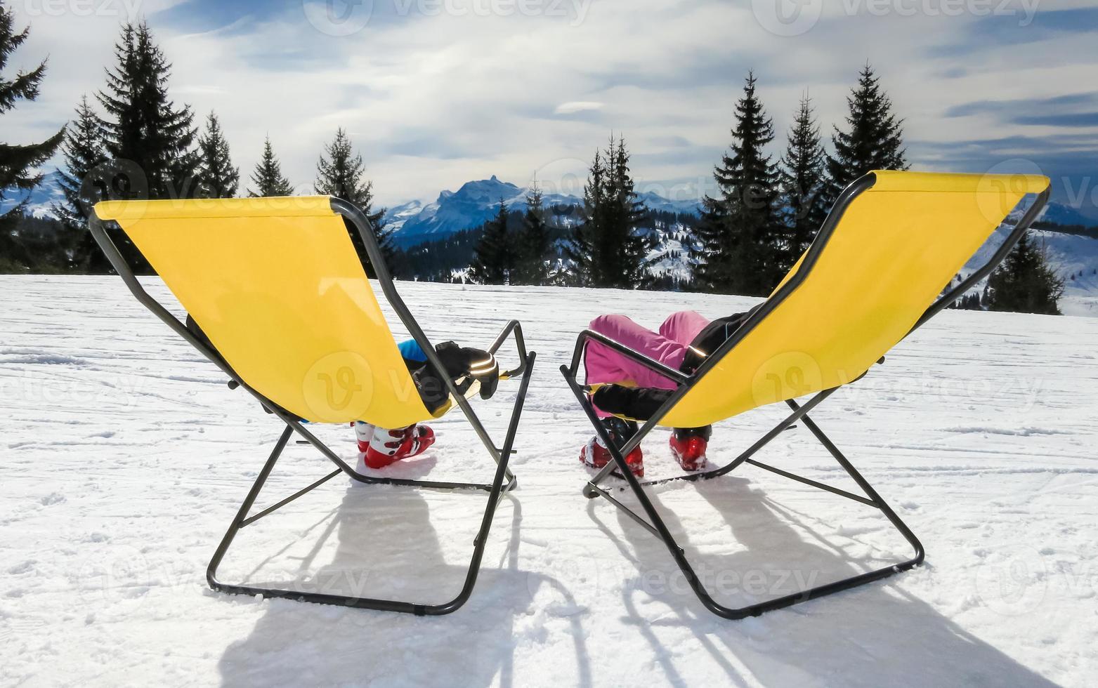 twee kinderen op de ligstoelen op de berg foto