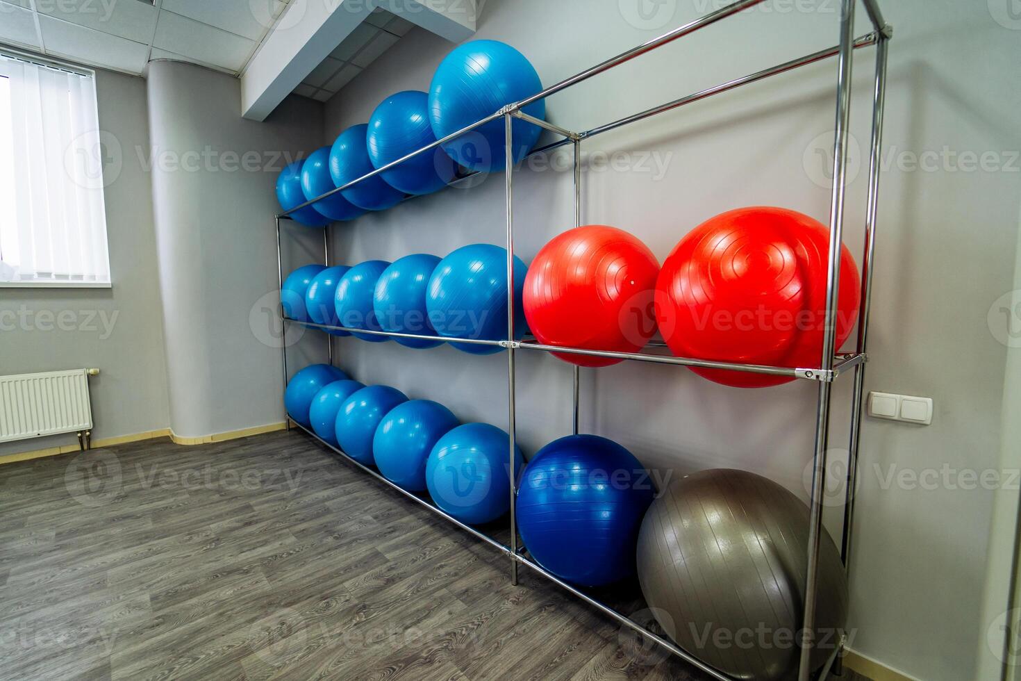 metaal staan Bij de muur met gekleurd geschiktheid ballen in de licht Sportschool. yoga en pilates hal met sport uitrusting binnen foto