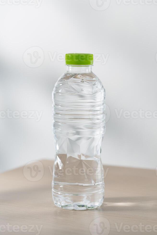 drinken water in plastic flessen Aan een houten tafel onder de ochtend- zonlicht. foto