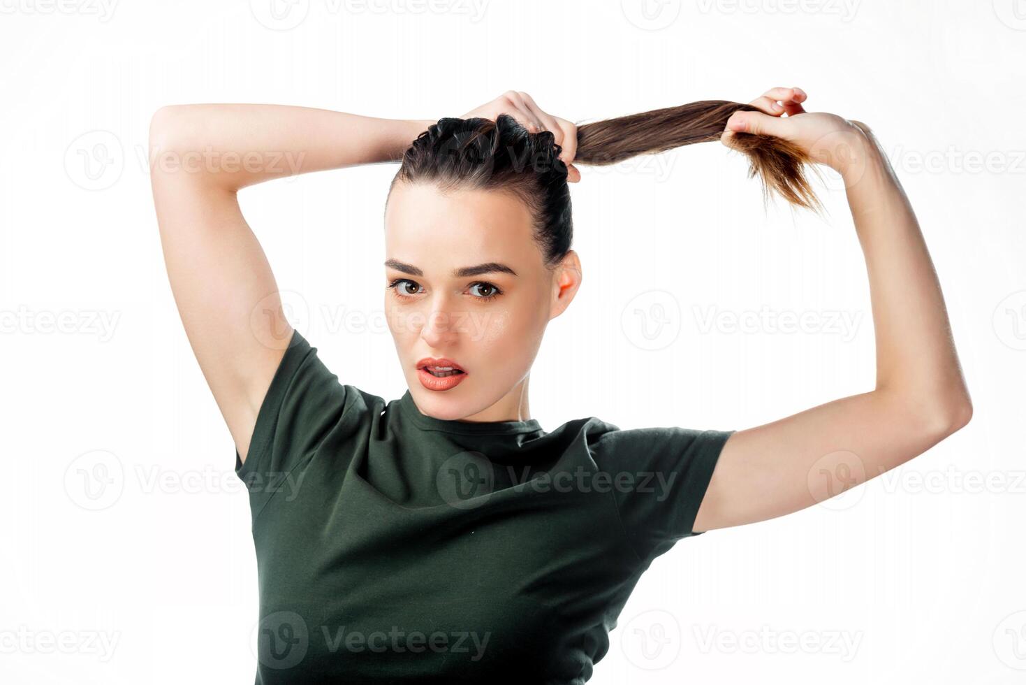 portret van jong meisje past zich aan haar haar- in een paardenstaart in studio. jeugd, inschrijving leeftijd en levensstijl concept. modieus jong vrouw koppelverkoop haar mooi gember haar- in paardenstaart. foto