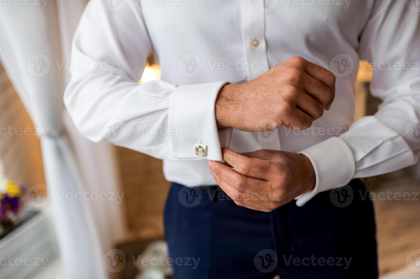 een bruidegom zetten Aan manchetknopen net zo hij krijgt gekleed in formeel dragen. Mens krijgen klaar voor werk foto