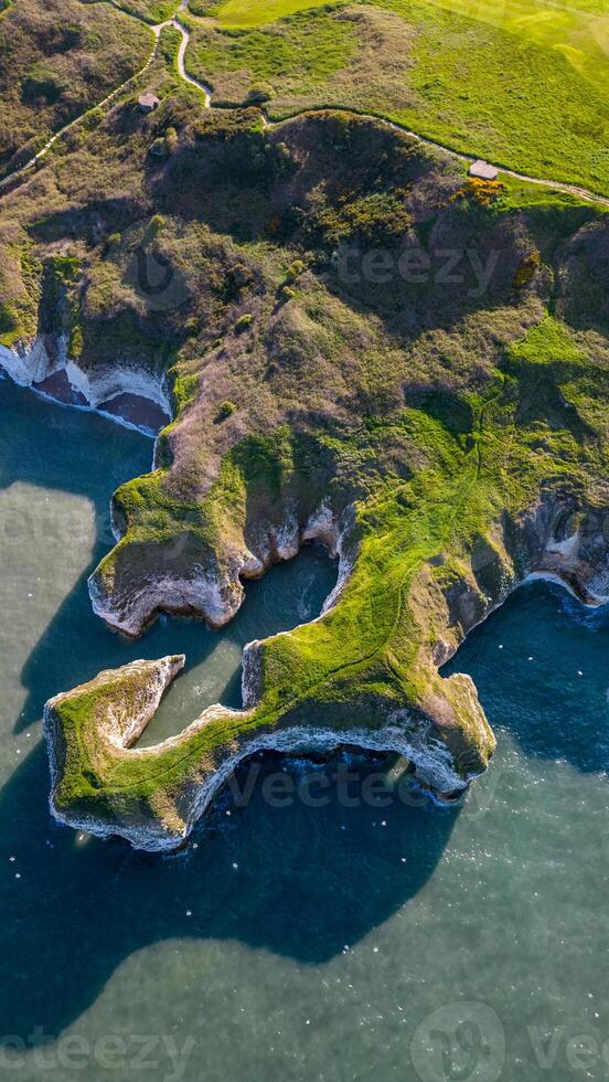 antenne visie van een robuust kustlijn met kliffen en groen vergadering de zee in Flamborough, Engeland foto