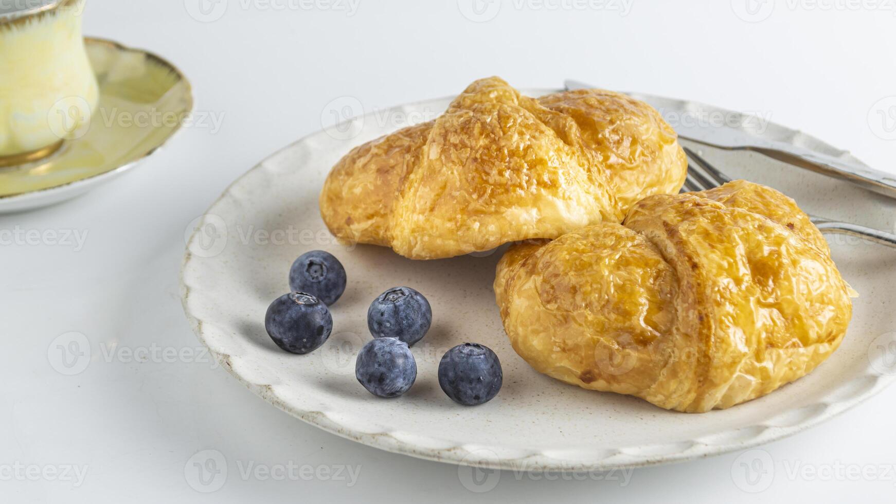 een croissant en bosbessen Aan een bord foto