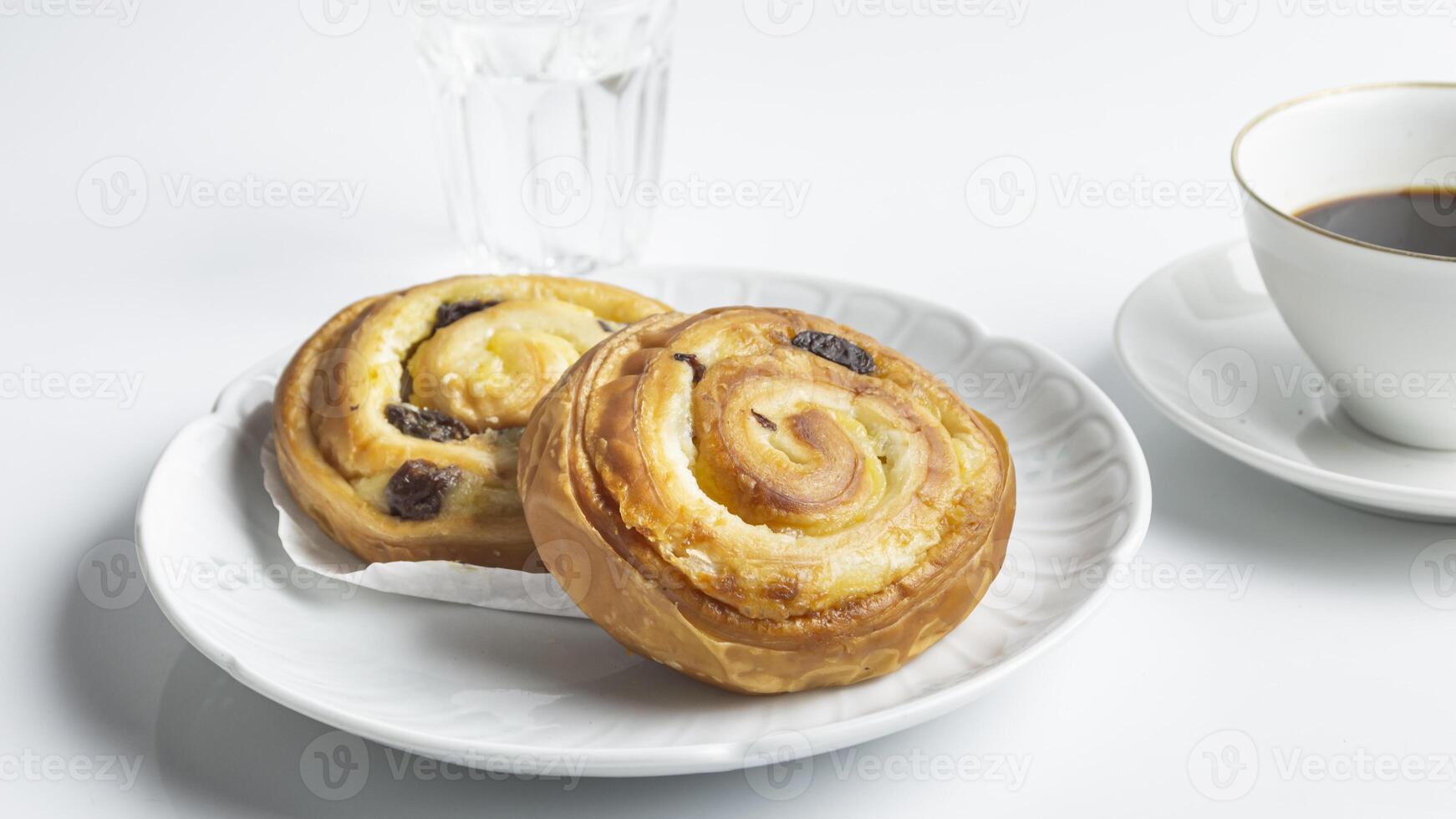 een bord met twee gebakjes en een kop van koffie foto