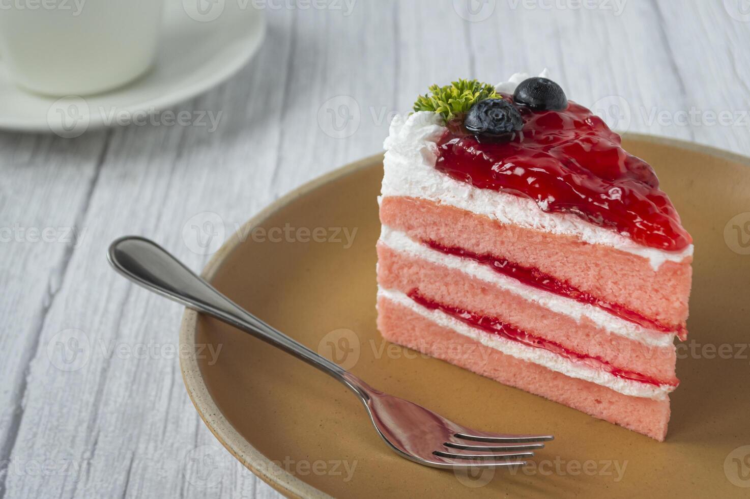 een plak van aardbei taart met bosbessen Aan top foto