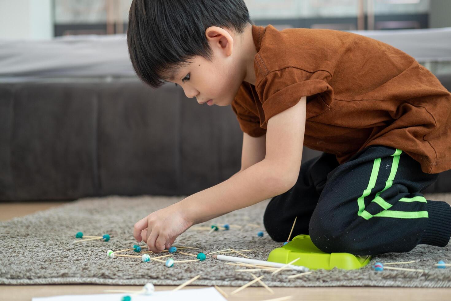 Aziatisch jongen spelen met plasticine in de kamer foto