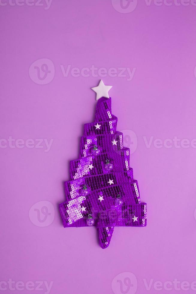 abstracte kerstboom gemaakt van glanzend lint met pailletten. minimalistisch creatief voor de nieuwjaarsvakantie foto