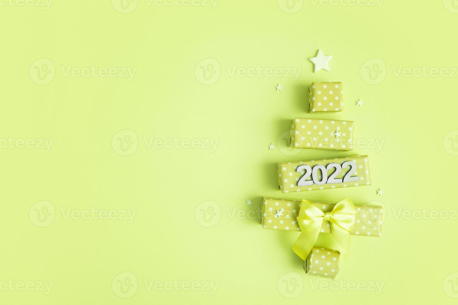 wenskaart met abstracte kerstboom gemaakt van geschenkdozen en nummers 2022 voor vrolijk kerstfeest en nieuwjaar foto