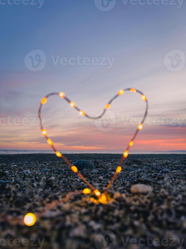 hart symbool met helder fee lichten Aan de strand foto