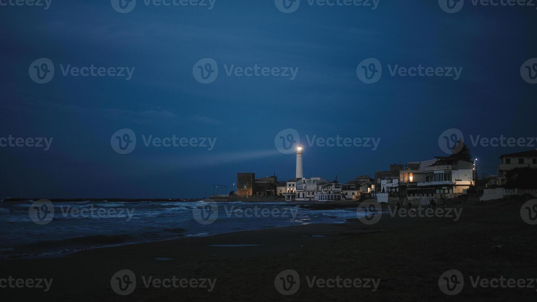 vuurtoren Aan de strand in de nacht foto