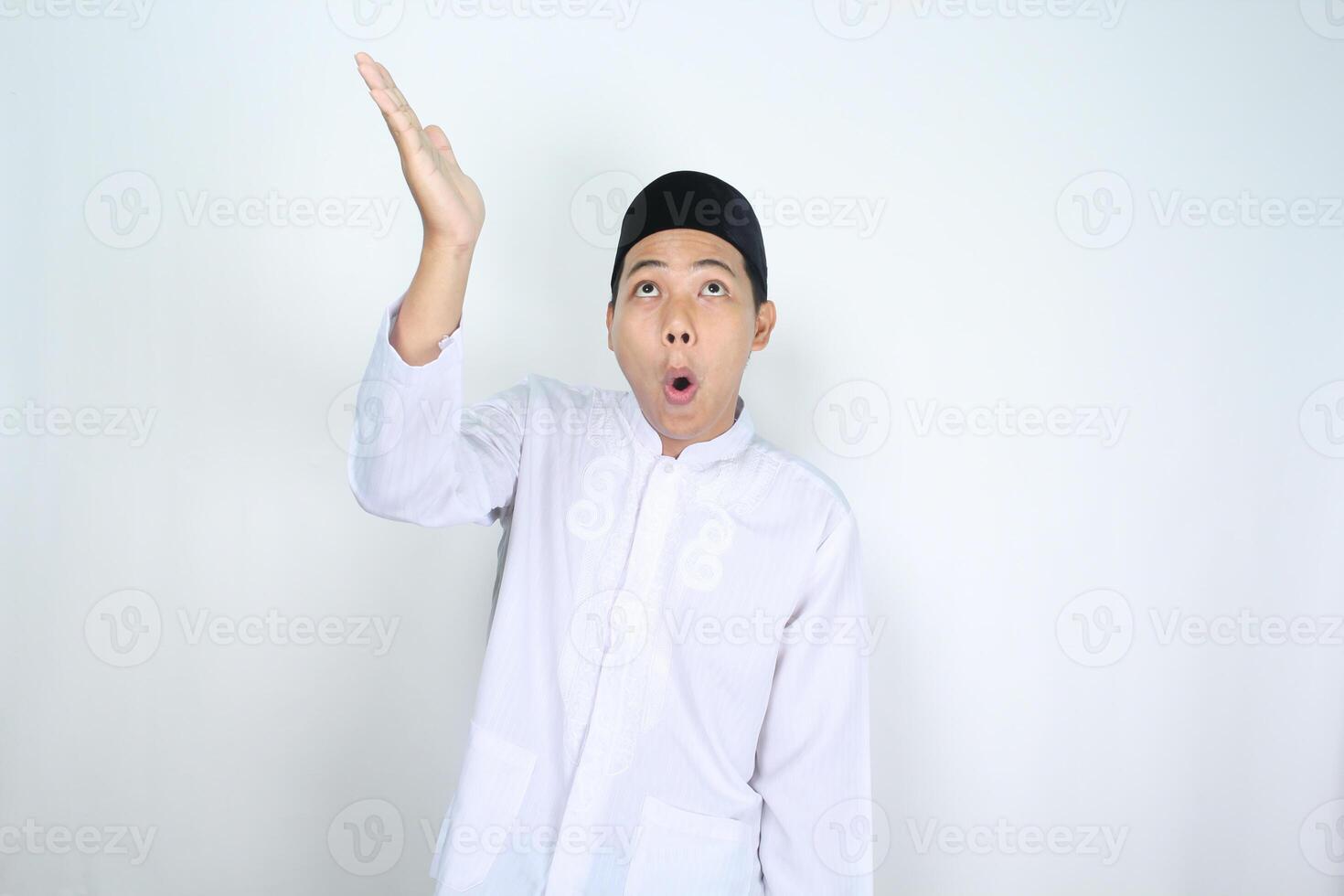 geschokt Aziatisch Mens moslim verhogen hand- bovenstaand naar presenteren geïsoleerd Aan wit achtergrond foto