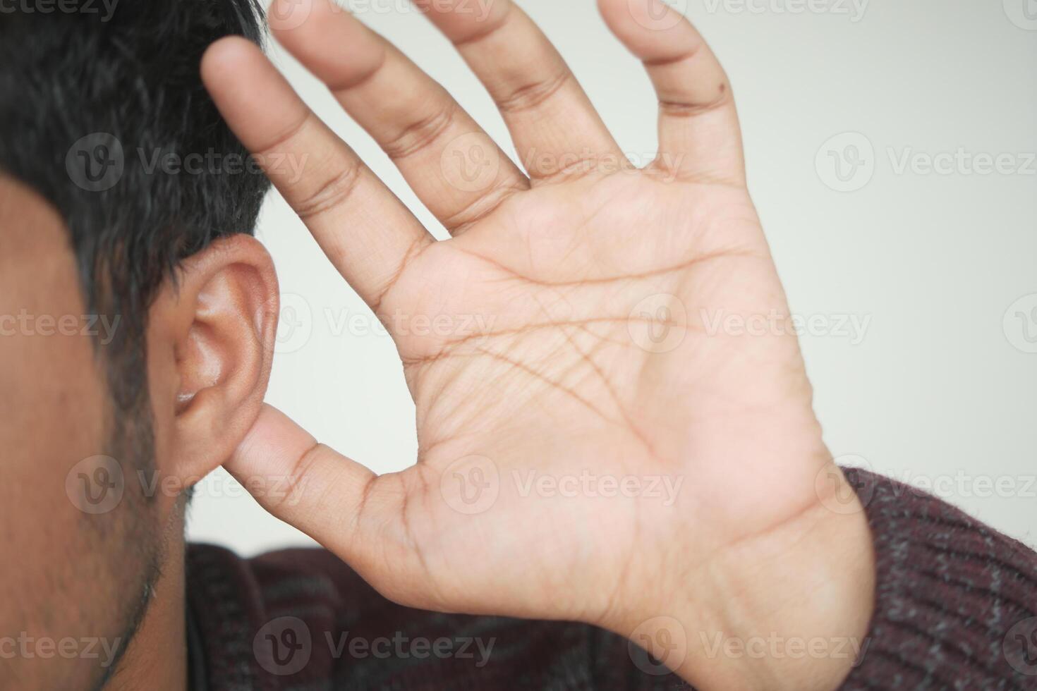 jonge man met oorpijn bij het aanraken van zijn pijnlijke oor, foto