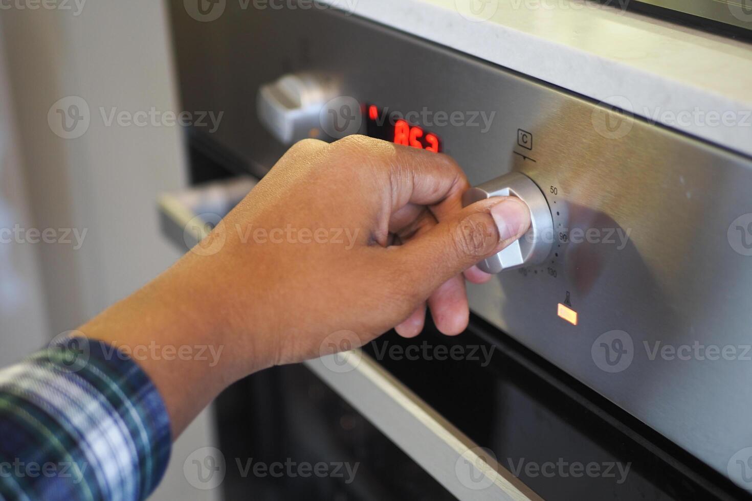 dichtbij omhoog van mannen hand- instelling temperatuur controle Aan oven. foto